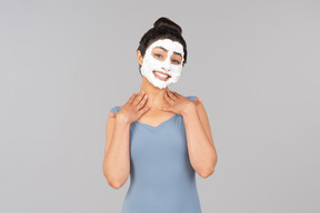 Femme avec un masque facial blanc sur souriant