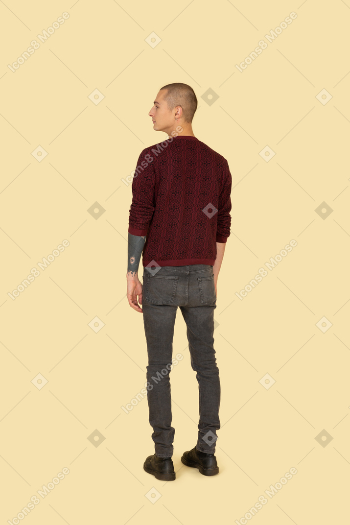 Vista posterior de un joven con un suéter rojo mirando a un lado
