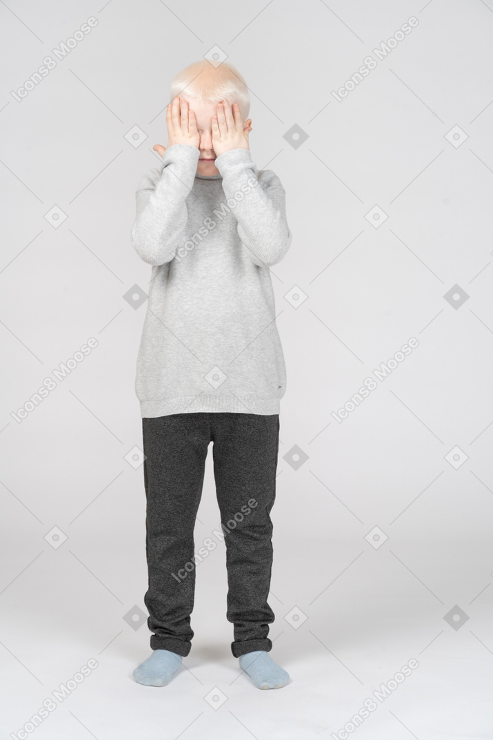 Little boy covering his eyes with hands