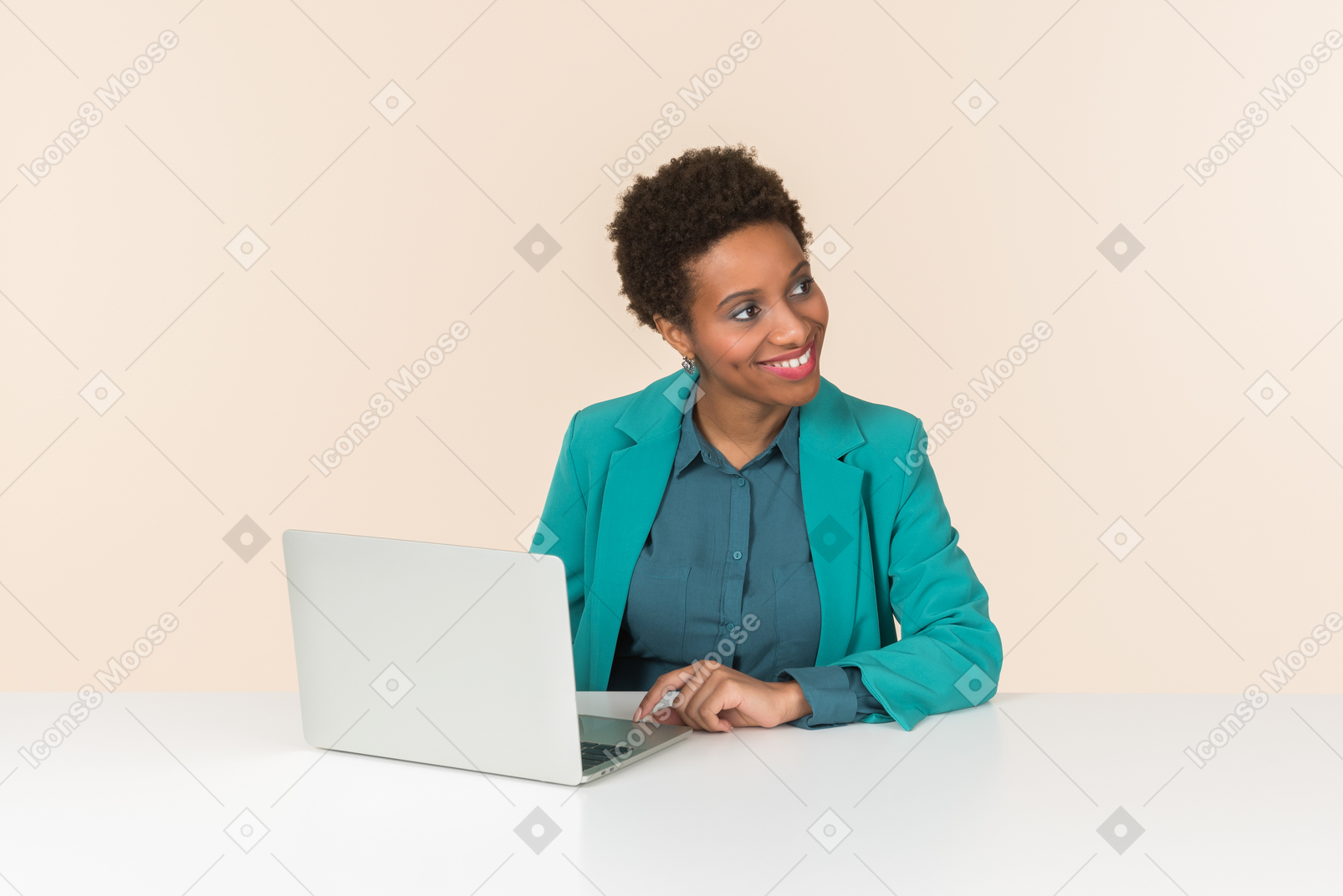 Young female office employee working on laptop and looking aside