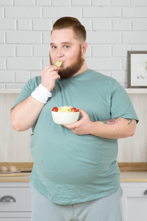 A man in sportswear eating a salad