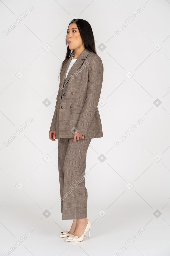 Three-quarter view of a pouting young lady in brown business suit