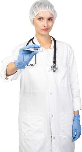 Vue de face d'une jeune femme médecin avec stéthoscope tenant un thermomètre