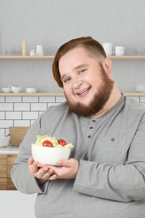 A man with a beard holding a bowl of food