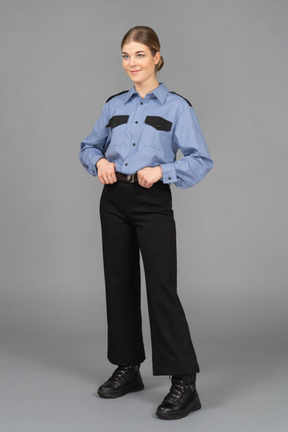 Female security guard standing with her hands on the belt