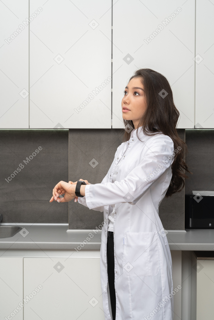 A female nurse looking aside while checking time