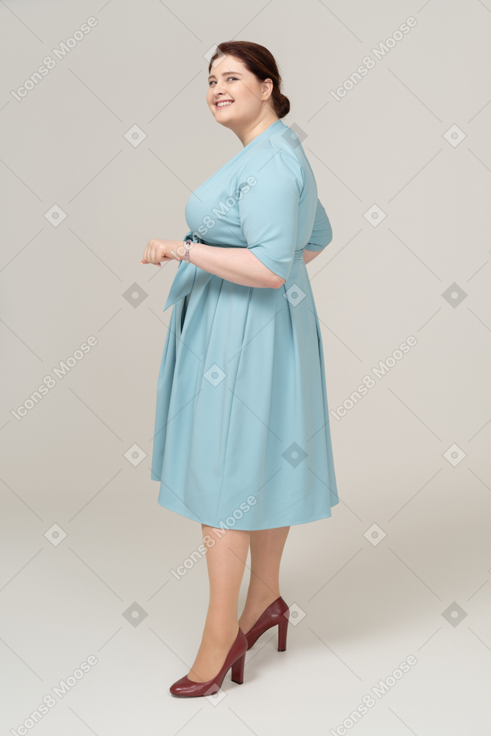 一个穿着蓝色裙子的快乐女人的侧视图