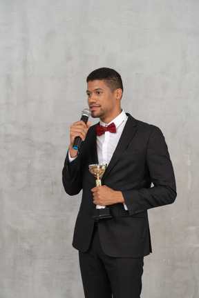 A man in a tuxedo holding a microphone