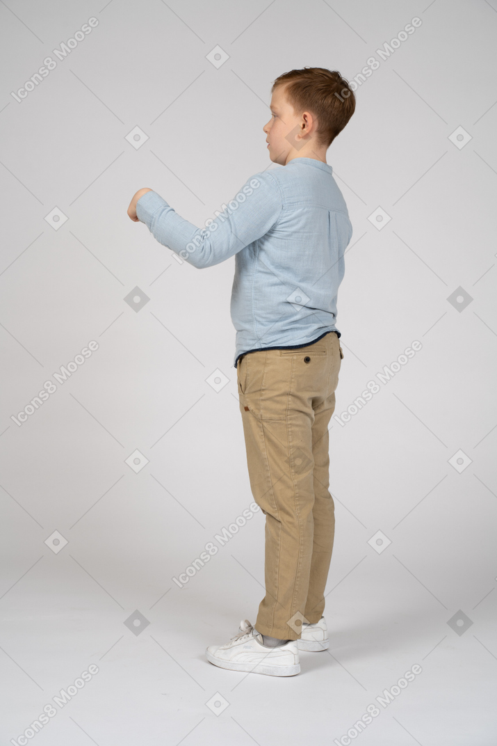 Side view of a boy pointing with finger