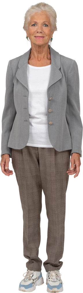 Vista frontal de una hermosa anciana en traje mirando a la cámara