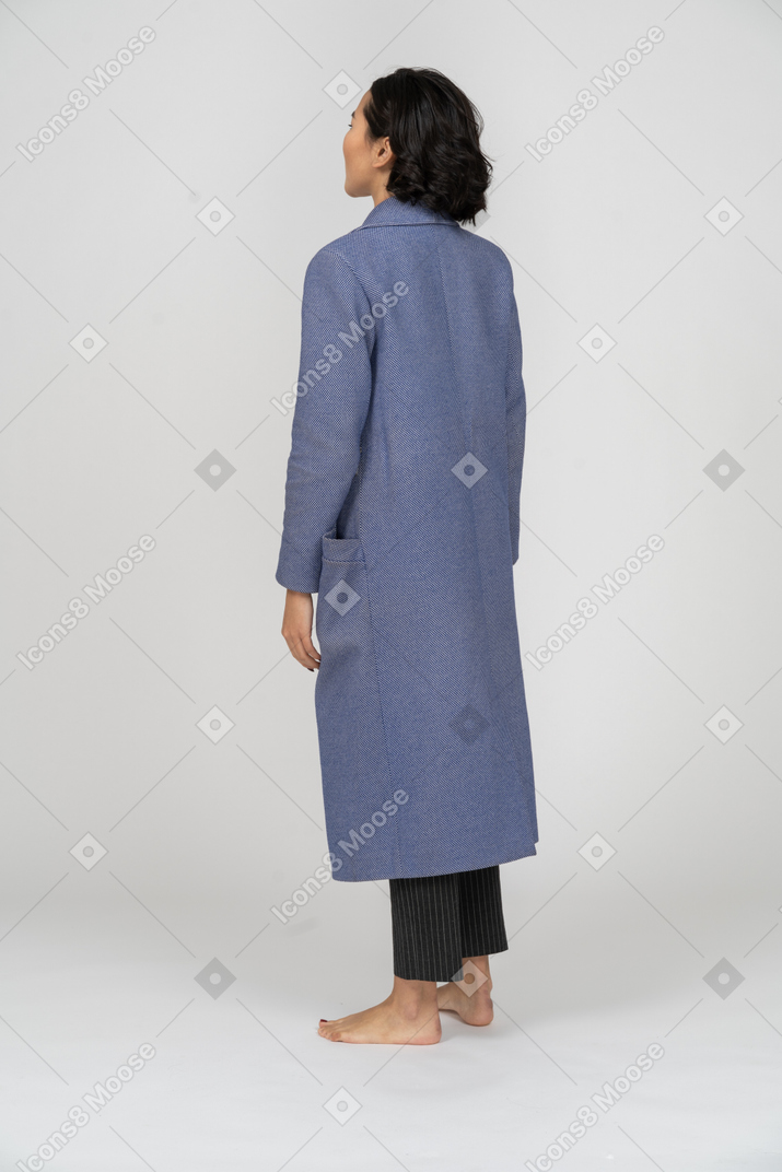 Vista traseira de uma mulher em pé de casaco