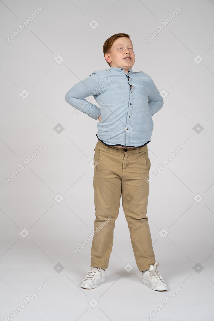一个男孩双手放在背上站立的正面图