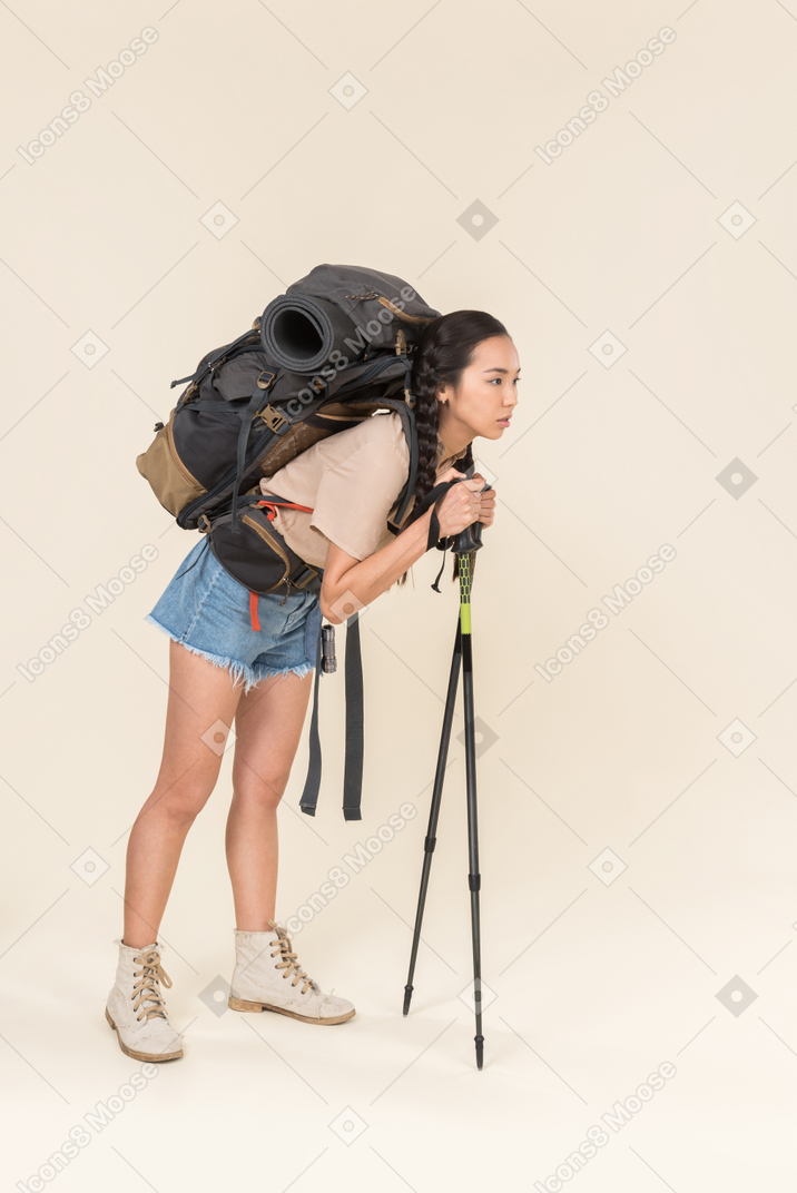 Mulher de caminhante cansado olhando andando usando postes de trekking
