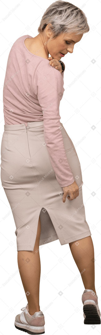 Rear view of a woman in casual clothes looking at her leg