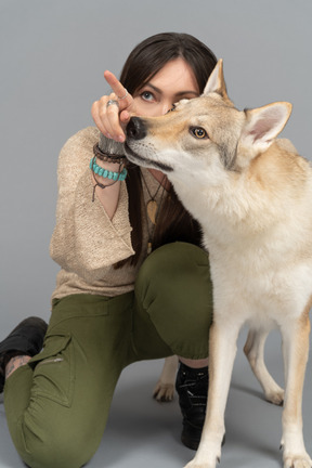 손가락으로 개를 가리키는 젊은 여자