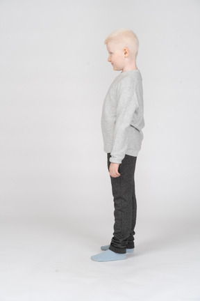 Side view of a little boy standing still