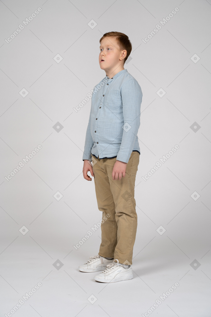 Vista lateral de um menino pensativo