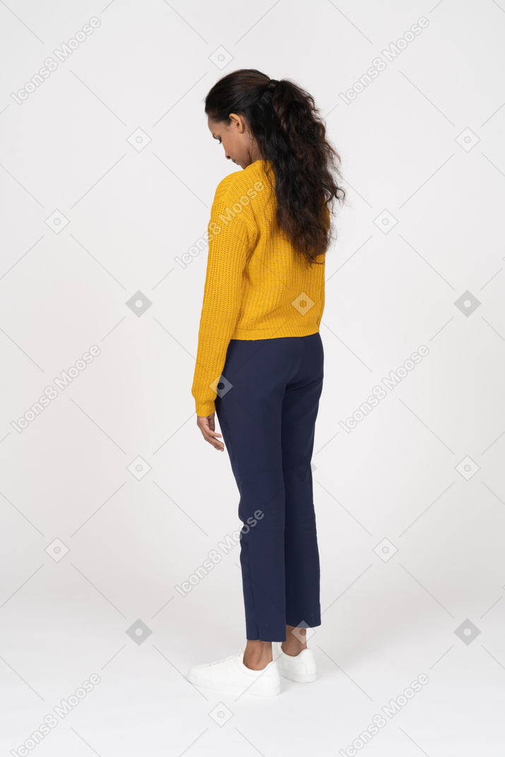 Rear view of a girl in casual clothes looking down