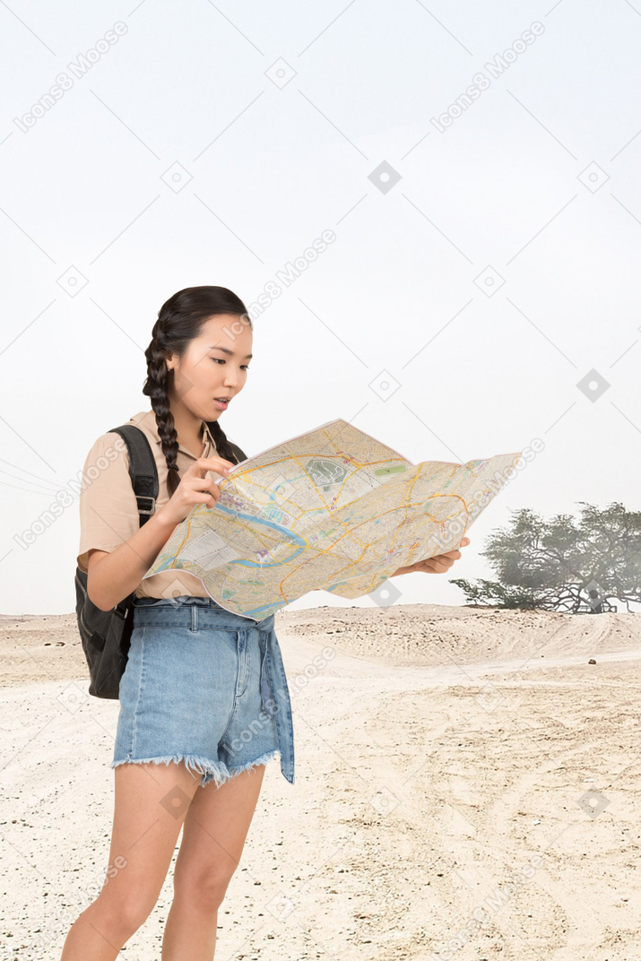 A woman looking at a map in the desert