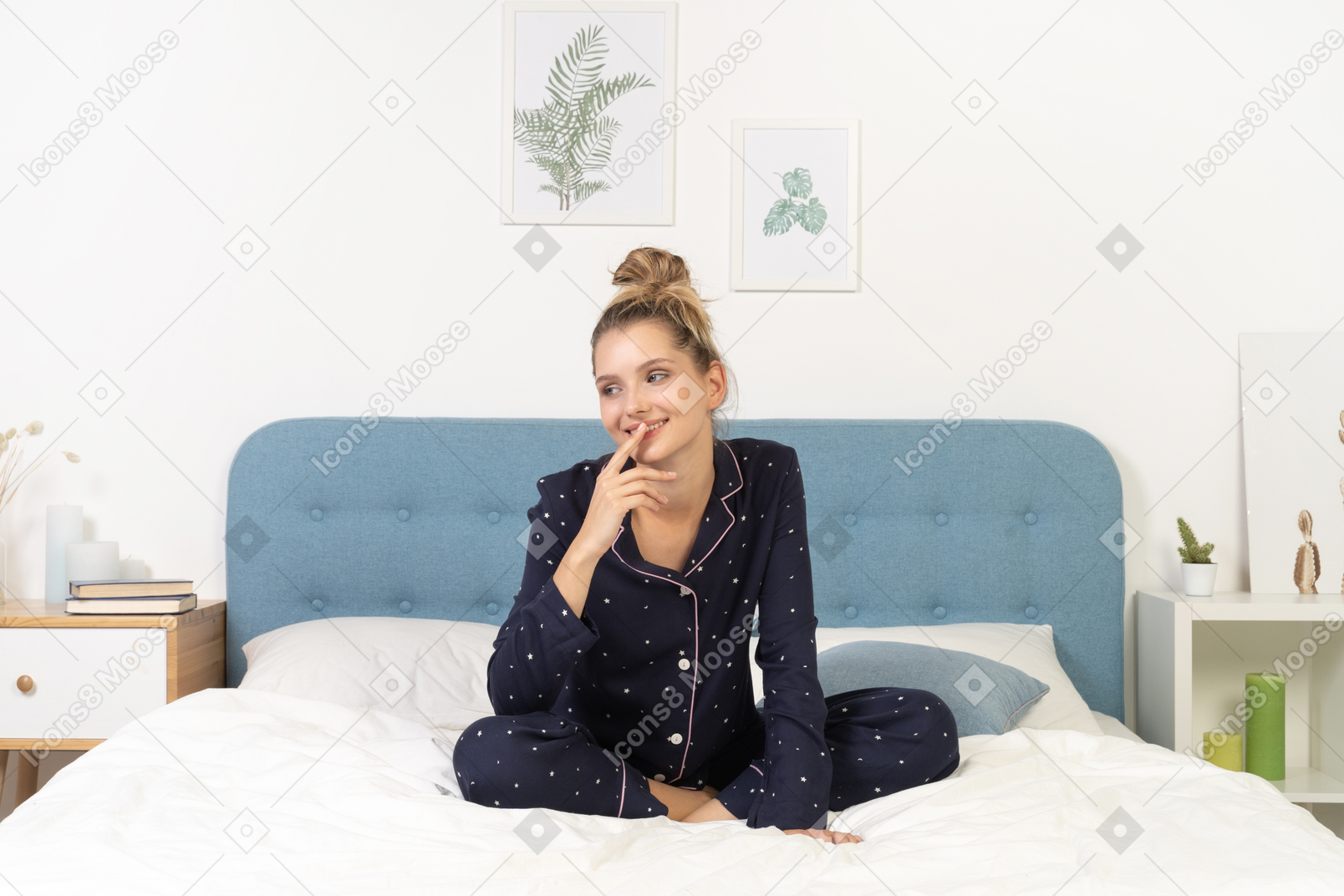 Front view of a pleased thoughtful young woman in pajamas staying in bed