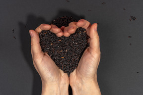 Heart shaped handful of black rice