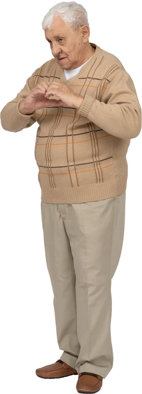 Front view of an old man in casual clothes making heart with fingers