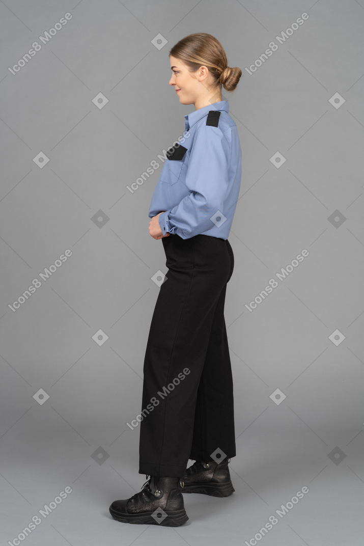 Female security guard standing in profile with her hands on the belt