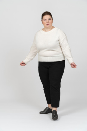 Surprised plump woman in casual clothes looking at camera