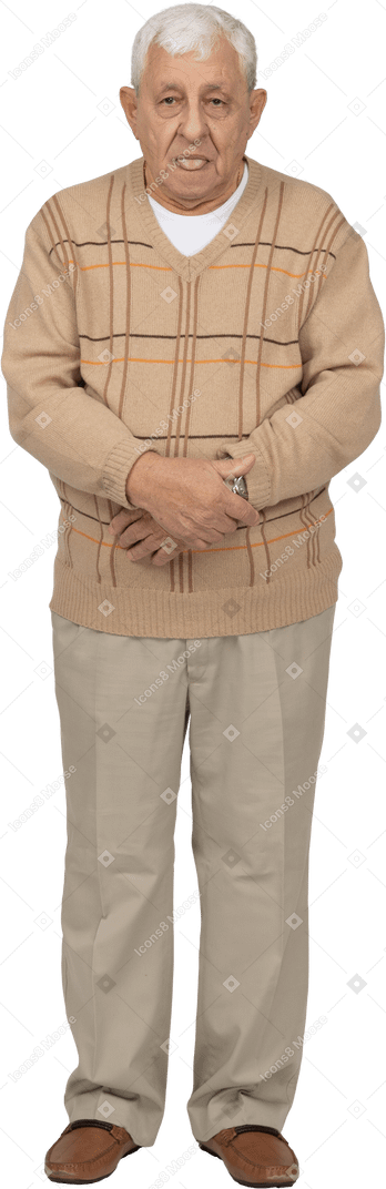 Front view of an old man in casual clothes showing tongue