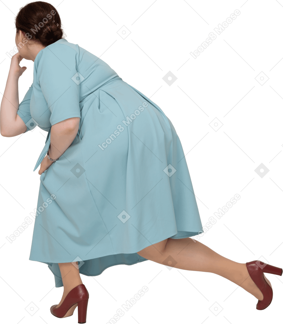 Женщина в синем платье сидит на корточках, вид сзади