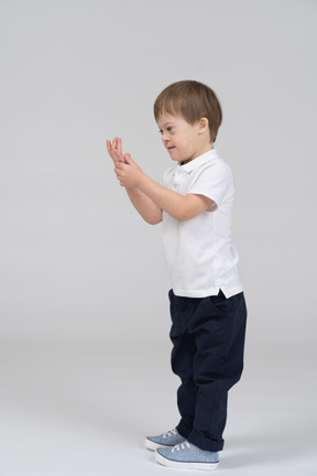 Side view of little boy examining his palm