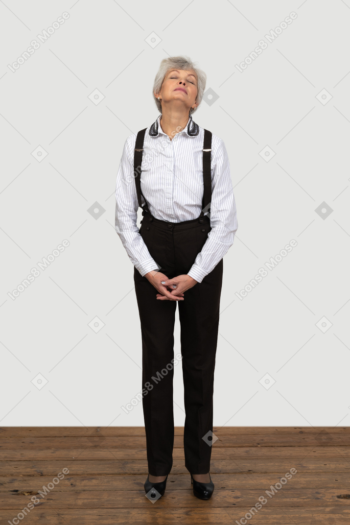 一位老疲惫的女性，在办公室的衣服做鬼脸，手牵着手的前视图