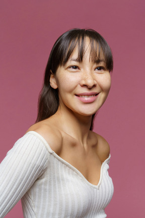 Vue de trois quarts d'une femme d'âge moyen à côté et souriant