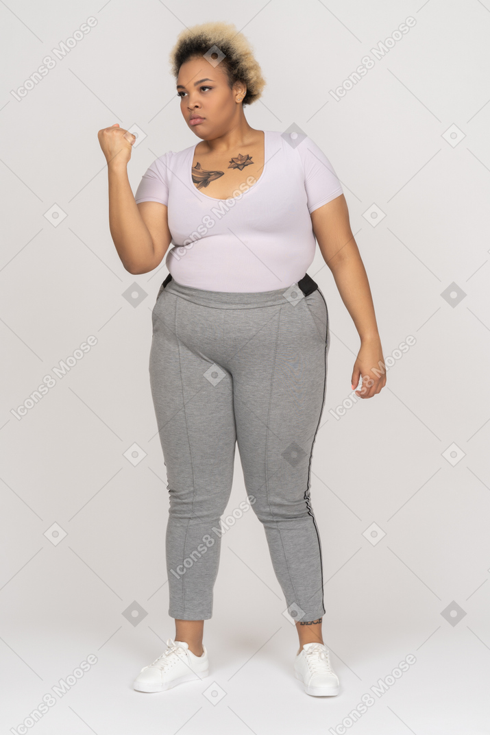 Angry plump black woman shaking a fist threatening somebody