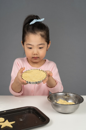 Bambina che impara a cuocere i biscotti