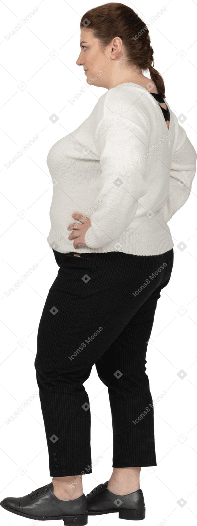 Mulher plus size com suéter branco em pé com as mãos nos quadris