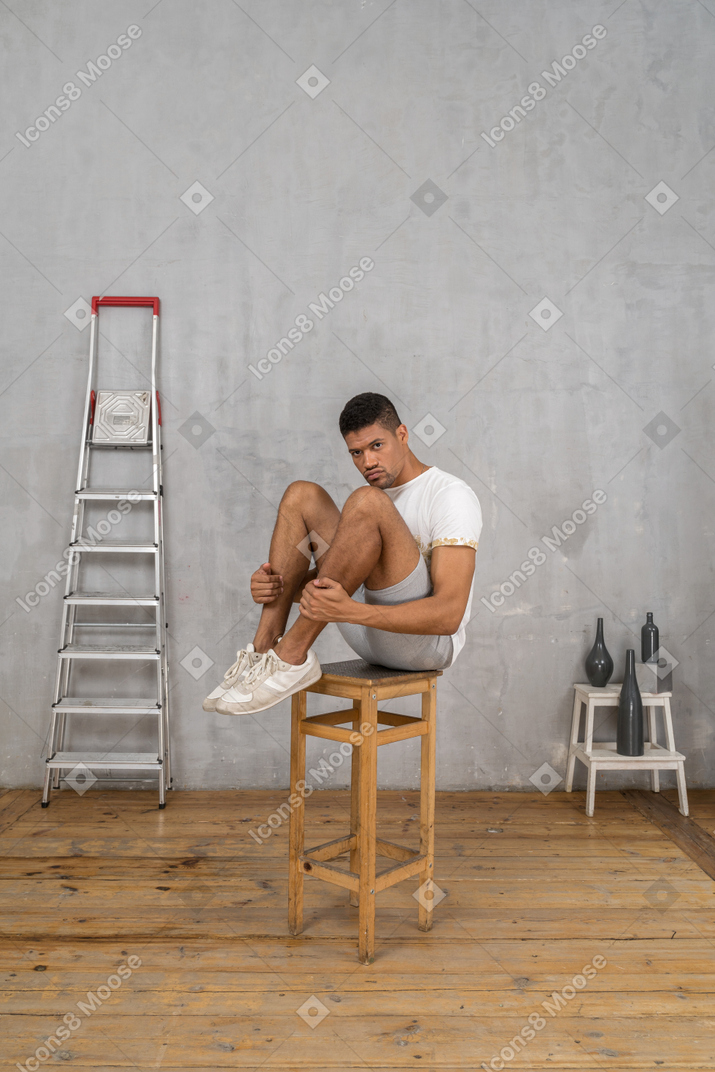 Man sitting on chair with his knees bent