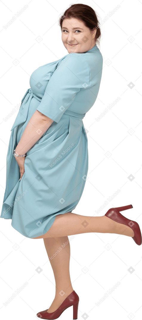 Вид сбоку женщины в синем платье, стоящей на одной ноге