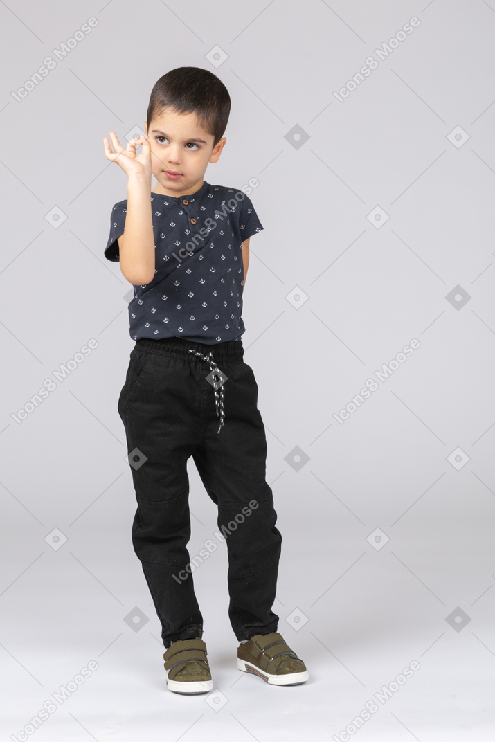 Front view of a cute boy showing ok sign