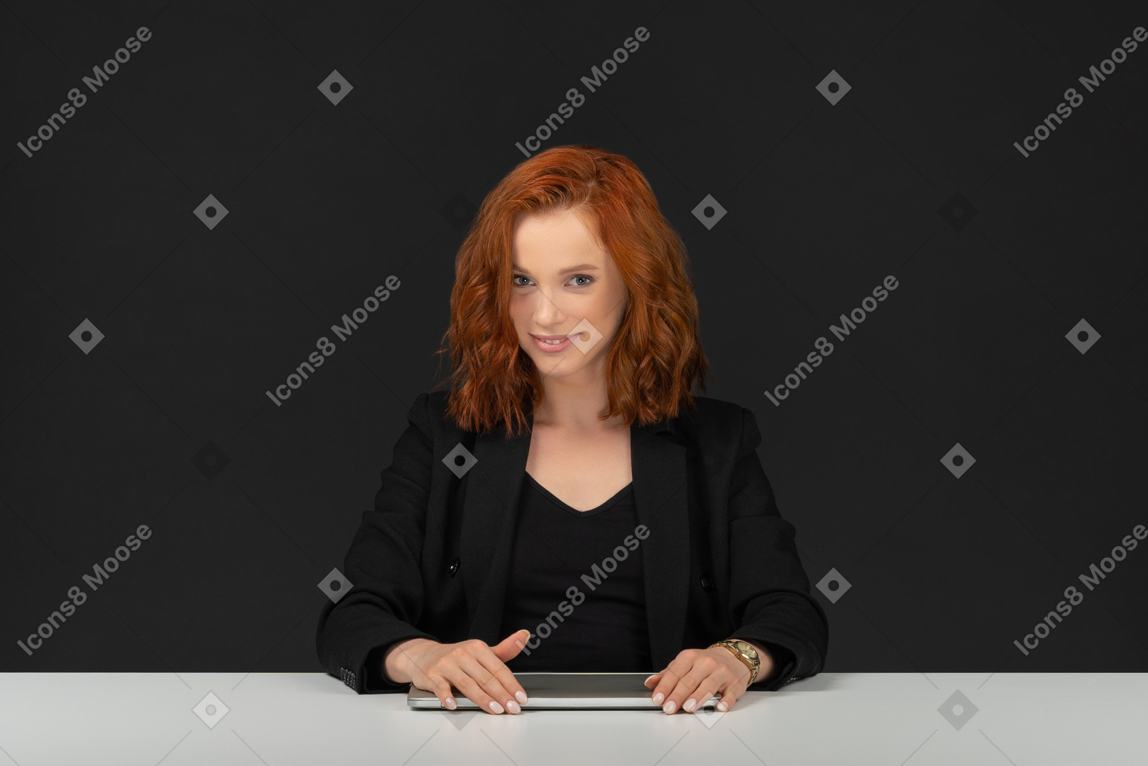 Cute young woman sitting at the table and smiling