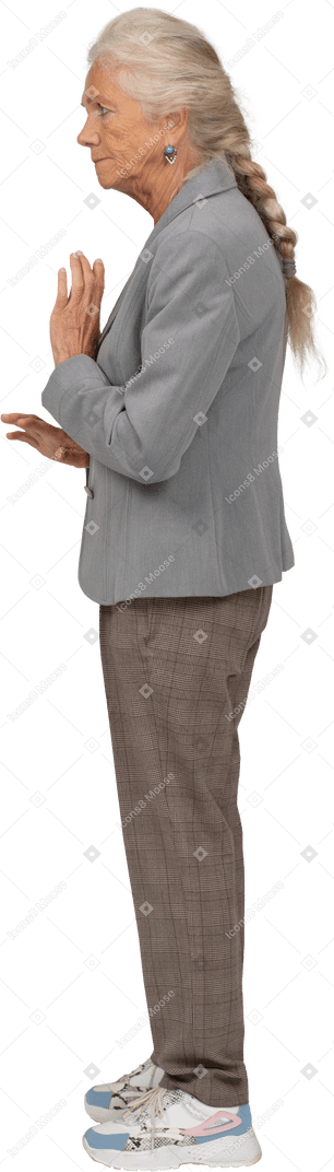 Side view of an old lady in suit showing stop gesture