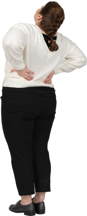 허리 통증으로 고통받는 흰색 스웨터에 플러스 사이즈 여자