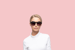 A woman wearing sunglasses and a white shirt