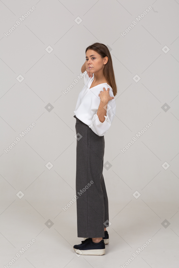 Вид сбоку молодой леди в офисной одежде, касающейся ее плеч