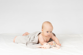 Baby girl covered in towel and holding a toy