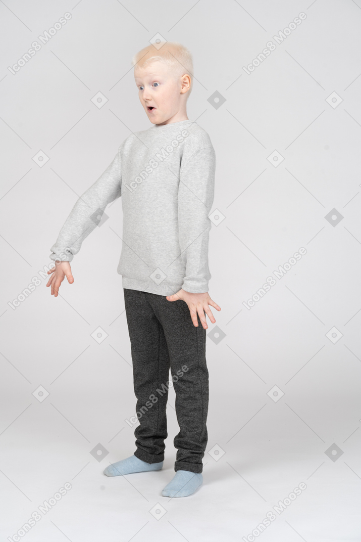 Little boy standing stunned with arms spread