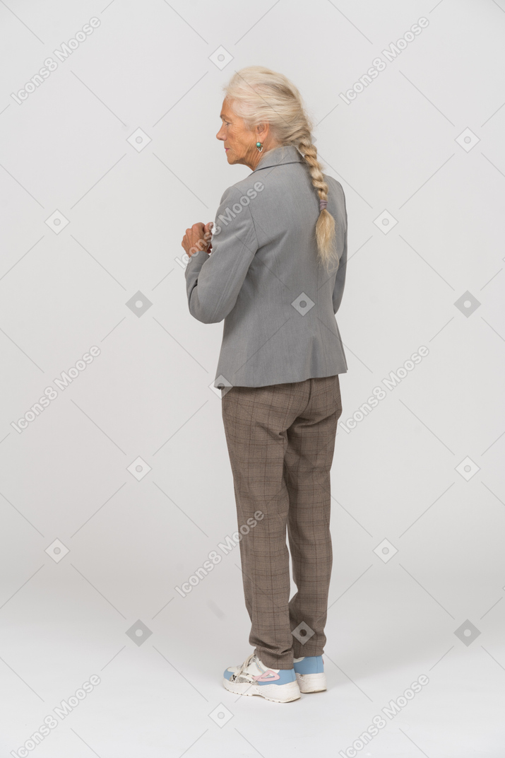 Rear view of an old lady in suit posing