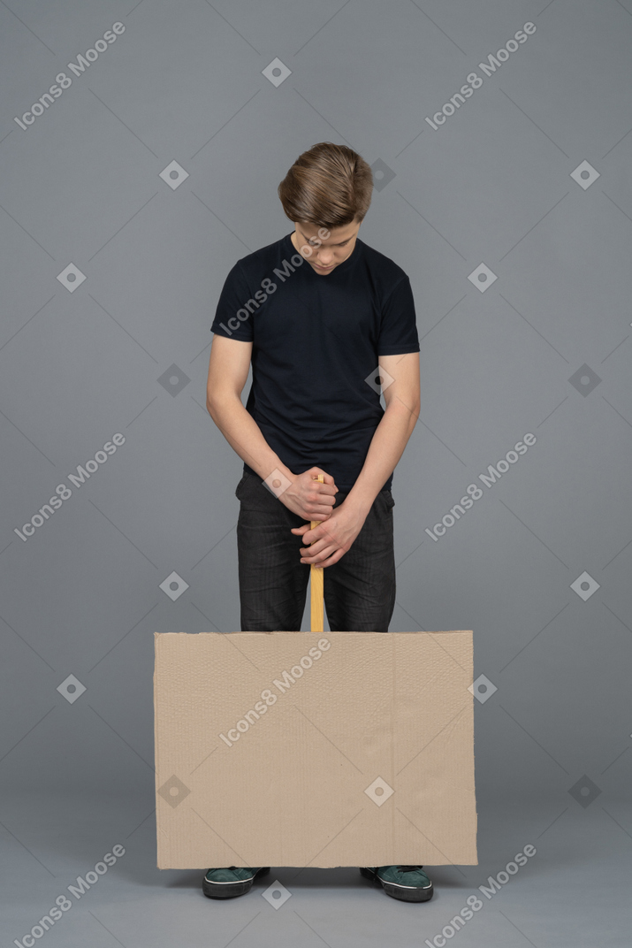 Depressed young man holding a poster upside down