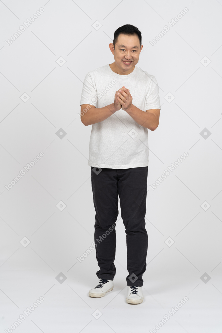 Front view of a happy man rubbing hands and looking at camera