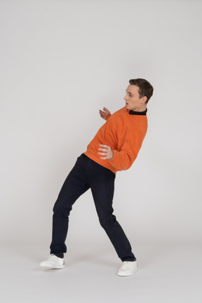オレンジ色のスウェットシャツジャンプの若い男